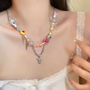 Close-up of double-layered beaded necklace featuring colorful heart charms and silver cross