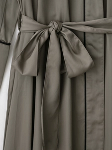 Detail van de satijnen badjas taille in donker olijfgroen met zwarte bies en gestrikte riem