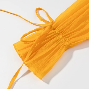 Detailed macro of yellow pleated fabric cuff with stylish self-tie ribbon design