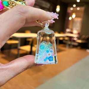 Side view of acrylic charm with colorful glitter, small flowers, and golden metal clasp