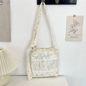 Detailed texture of beige floral lace shoulder bag with tiered ruffles and bows
