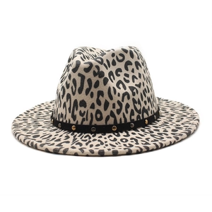 Detail of leopard print fedora hat featuring black band with gold and silver metal studs