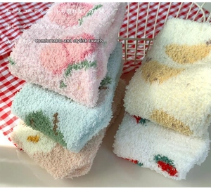 Detail of coral fleece socks featuring fruit patterns like peaches and strawberries