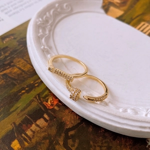 Macro detail of 18K gold plated T-shape and nail design open rings with micro-inlaid stones
