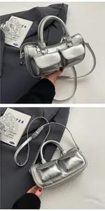 Close-up of metallic silver Boston bag featuring dual front flap pockets and zip closure