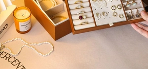 Detailed interior of brown leather jewelry box with compartments for rings and earrings