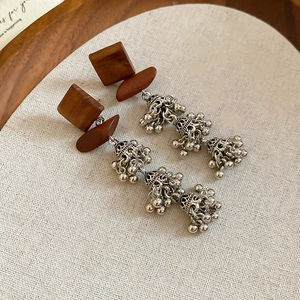 Détail des boucles d'oreilles carrées en bois avec glands argentés rétro et cloches Jhumka