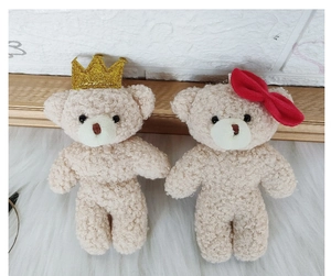 Detail of mini teddy bear plush keychains with golden crown and red bow decoration