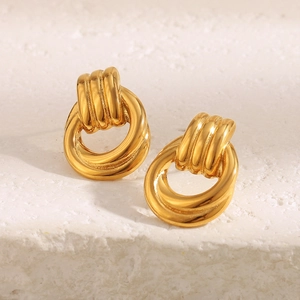 18K gold plated stainless steel twisted hoop earrings on a textured stone background