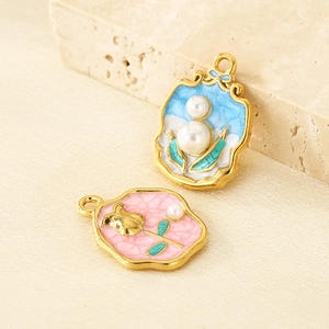 Vue macro de pendentifs émaillés vintage français avec bords dorés, perles et fleurs