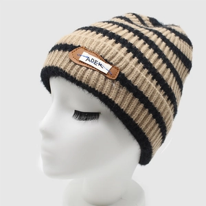 Striped knit beanie with ADER leather patch and warm ribbed wool texture on model