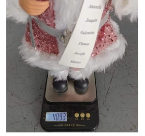 Pink sequin Santa Claus figurine weight measurement showing 409.3 grams on scale