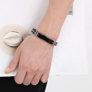 Close-up of a stylish men's black silicone bracelet with silver clasp on a wrist