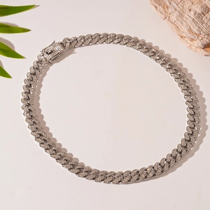 Macro shot of silver Cuban link necklace with micro-paved rhinestones on premium background