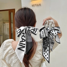 Detail of lace bow hair clips with pearls, featuring houndstooth and floral patterns