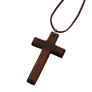 Close-up of a brown wooden cross pendant with natural wood grain on a dark cord
