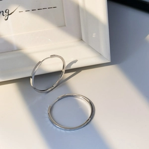 Macro shot of S925 sterling silver hoop earrings with sparkly textured diamond cut pattern