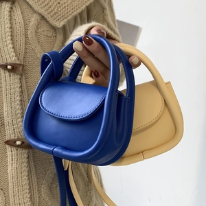 Mini sac à bandoulière en cuir en bleu roi et beige porté par un mannequin