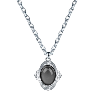 Gros plan d'un pendentif en argent vintage avec détails en relief et gemme ovale