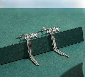 Vue détaillée macro de boucles d'oreilles HAPPY en argent S925 avec longues chaînes à pompons