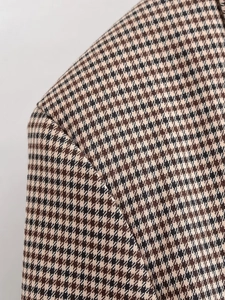 Détail rapproché du blazer à motif pied-de-poule montrant la texture tissée et la couture