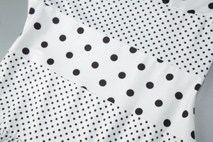 Dettaglio del tessuto a pois bianchi vintage con elegante fascia in vita dell'abito