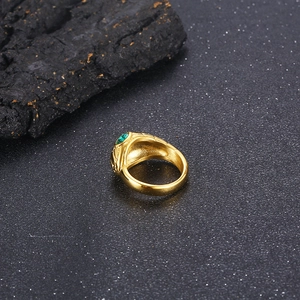 Macro shot of punk style snake ring featuring green crystal eyes and scale texture