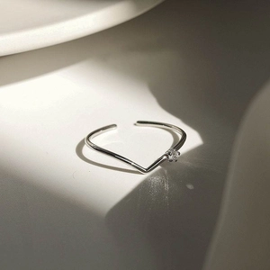 Close-up of S925 sterling silver V-shaped ring featuring a single sparkling round gemstone