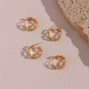 Close-up of C-shaped 18K gold plated chain earrings with green and blue enamel details
