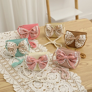 Détail de six petits sacs en paille tissée pour enfants avec nœuds papillon colorés