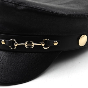 Detail of black leather baker boy hat with golden horsebit buckle and metal buttons