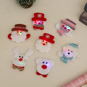 LED Christmas brooch set with Santa, snowman, and reindeer shapes in soft fabric