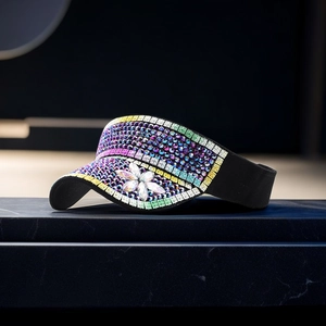 Detailed close-up of colorful rhinestones and floral gem design on a black sun visor hat