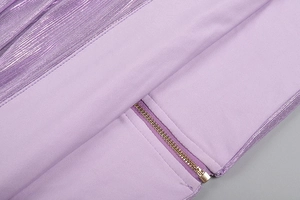 Detail of purple dress featuring metallic zipper and shiny pleated fabric textures