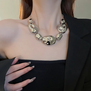 Close-up of silver irregular metal bead necklace on model with polished pleated design