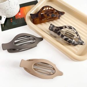 Detail of four matte oval claw clips in leopard print and solid neutral colors