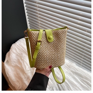 Detail of woven straw bucket bag with lime green leather strap and magnetic closure