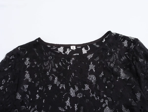 Close-up of black lace dress featuring a round neck and intricate floral texture details