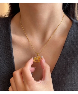 Close-up of 18k gold plated rocking horse pendant on a delicate bead chain necklace