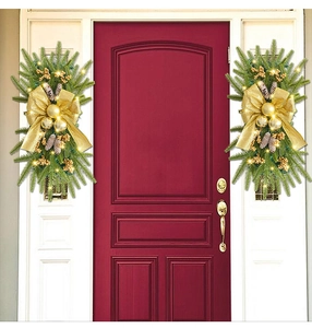 Symmetric Christmas teardrop swags with gold bows and lights on a red door