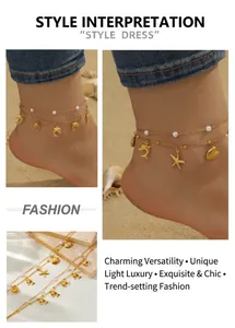 Detail of double-layer gold anklet with shell, starfish, and dolphin charms on beach