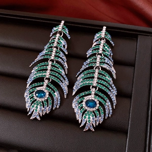Detail of vintage peacock feather drop earrings with blue stones and crystals