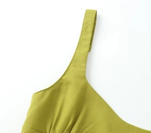 Macro detail of high-quality lime green woven fabric and delicate shoulder strap stitching