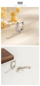 Close-up of small silver huggie hoop earrings with 5 micro-pave cubic zirconia stones