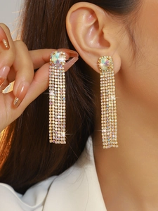 Close-up of model wearing elegant long tassel earrings with sparkling colorful rhinestones