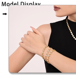 Detail view of model wearing layered gold flower bracelets with sparkling zircons