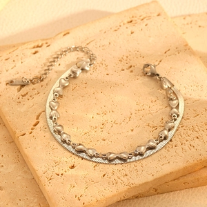 Détail du bracelet double couche argenté avec cœurs et chaîne serpent sur pierre