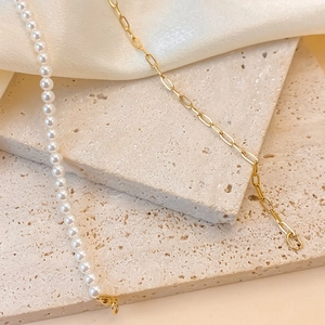 Detail showing vintage gold paperclip chain spliced with white faux pearls and lobster clasp