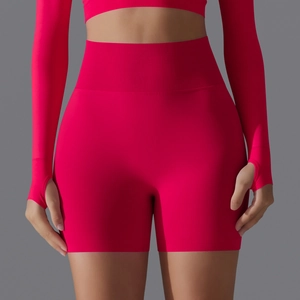 Detail of seamless ribbed high waistband on rose red yoga shorts for tummy control