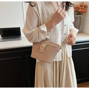 Detailed macro of apricot waffle textured leather bag with round gold buckle